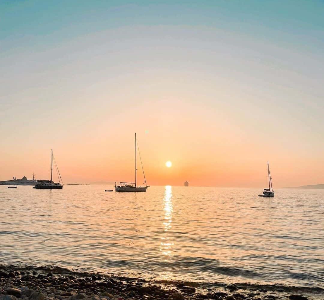 mykonos-sunset-greece-pilgrimage Mykonos sunset with sailboats greece pilgrimage tour