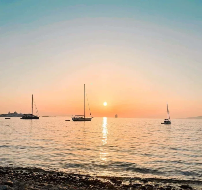 mykonos-sunset-greece-pilgrimage Mykonos sunset with sailboats greece pilgrimage tour